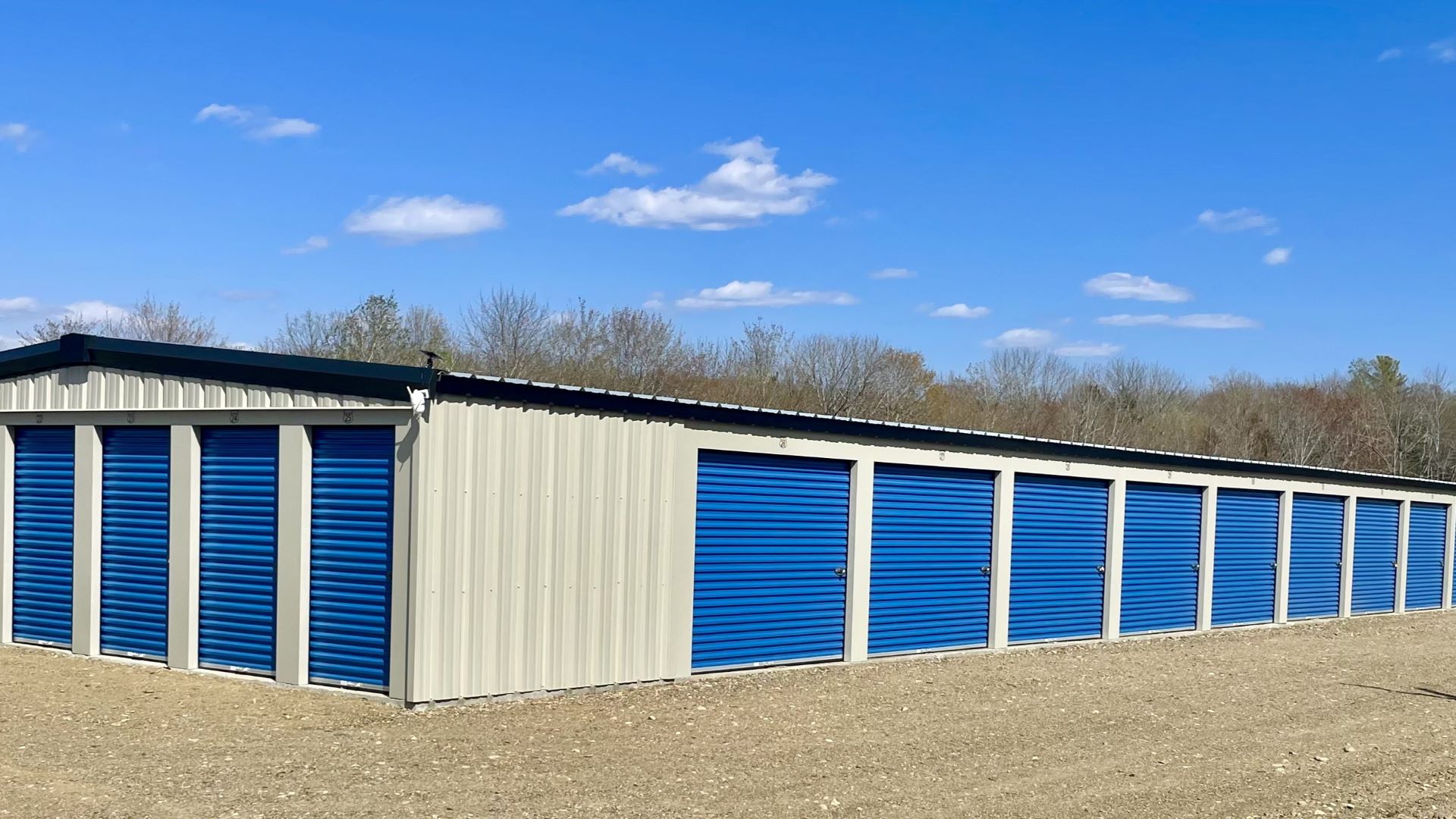 A self storage building with blue shutter doors. 